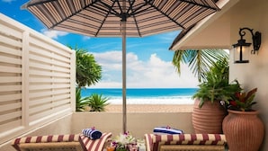 A balcony with wicker furniture, a table with drinks, and a view of the beach. - Taj Fort Aguada Resort & Spa, Goa (Candolim)