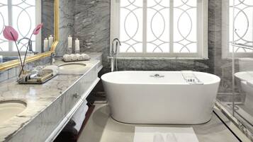 A modern bathroom with a freestanding bathtub, marble countertops, and a large window with decorative glass panels.