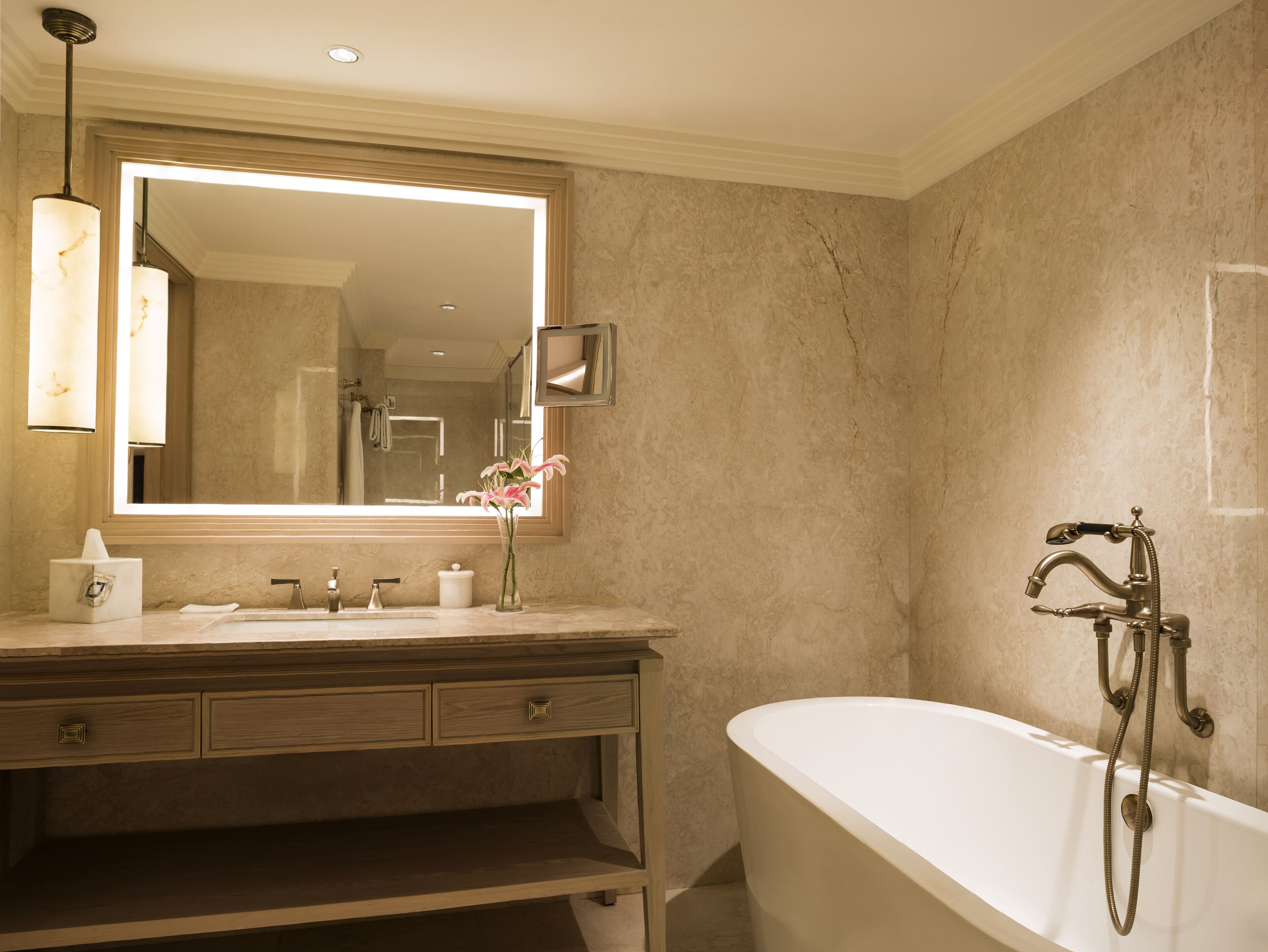 A bathroom with a large mirror, a bathtub, a vanity with drawers, and a towel rack.
