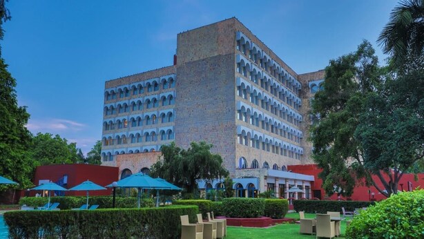 A hotel with a courtyard featuring outdoor seating and a swimming pool.