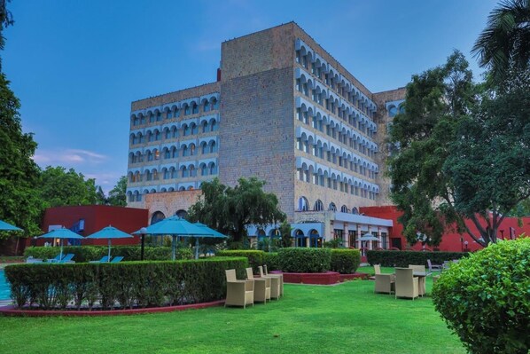 A hotel with a courtyard featuring outdoor seating and a swimming pool.