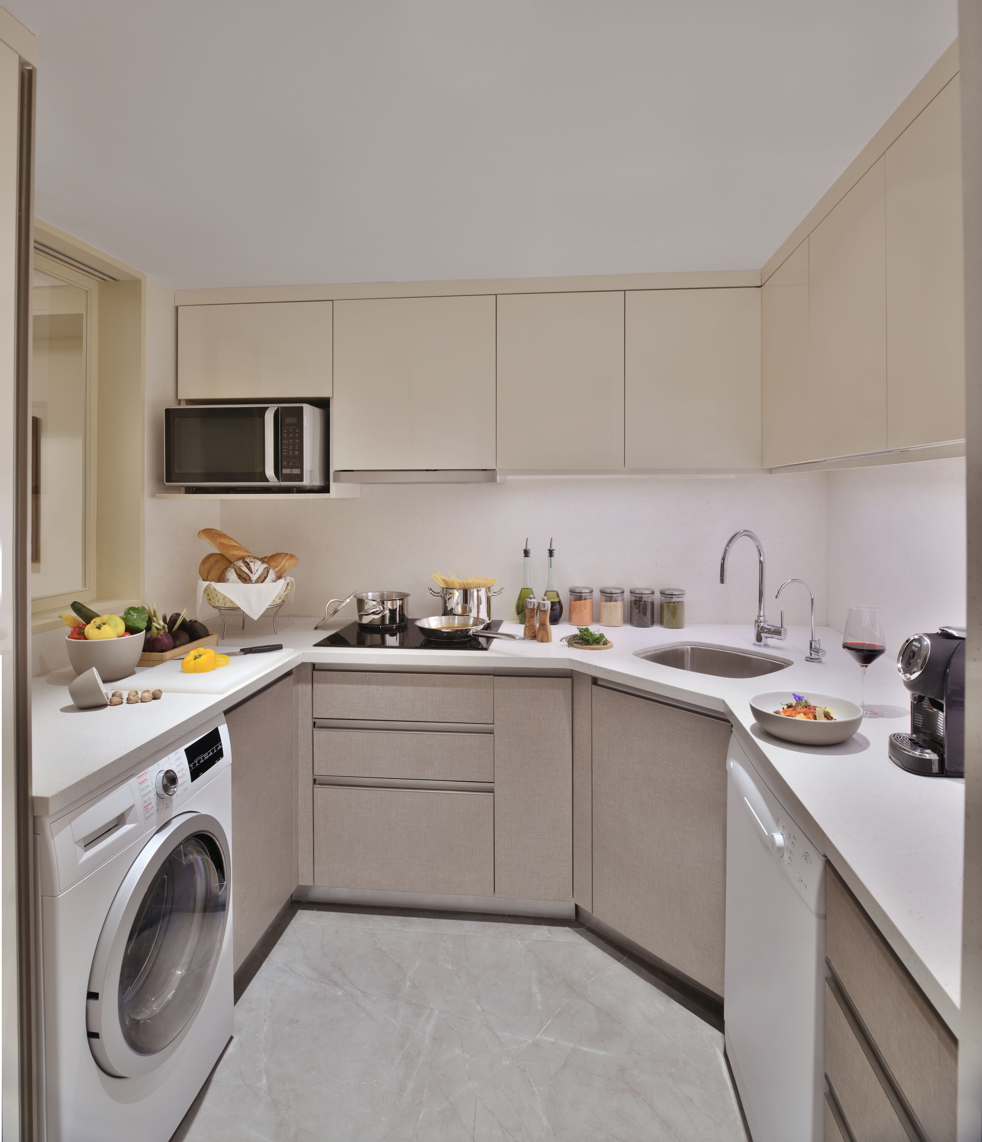 A modern kitchen with a built-in washer, a microwave, and a sink.