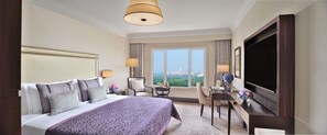 A hotel room with a large bed, a desk, a TV, and a window with a city view. - Taj Mahal, New Delhi (New Delhi)