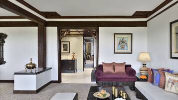 Amplia sala de estar con un sofá, una mesita de centro y objetos decorativos. Un pasillo conduce a un comedor.