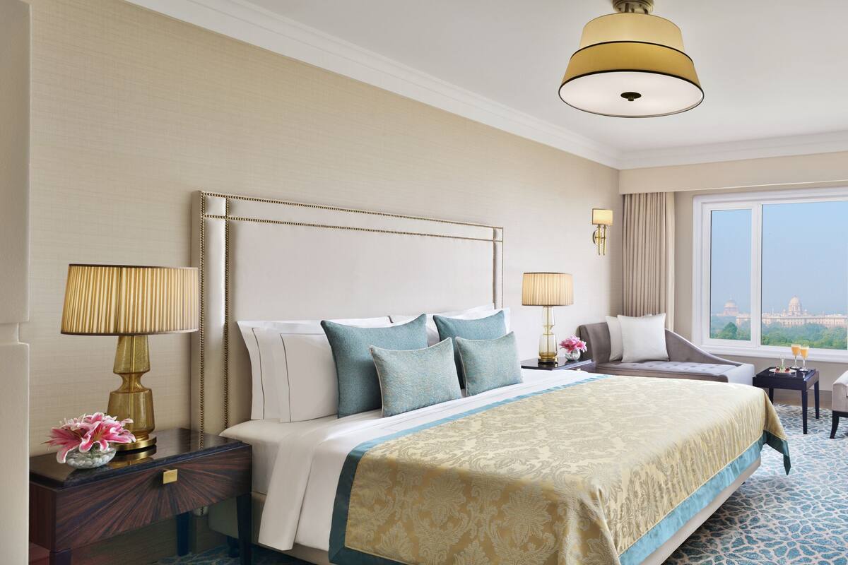 Habitación de hotel con una cama grande, un sofá, un televisor y vistas a la ciudad.