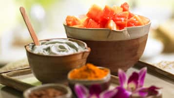 A tray with bowls of food and condiments, including a bowl of diced fruit and a bowl of yogurt.