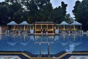A pool area with a clear view of the water, lounge chairs, and a gazebo structure.