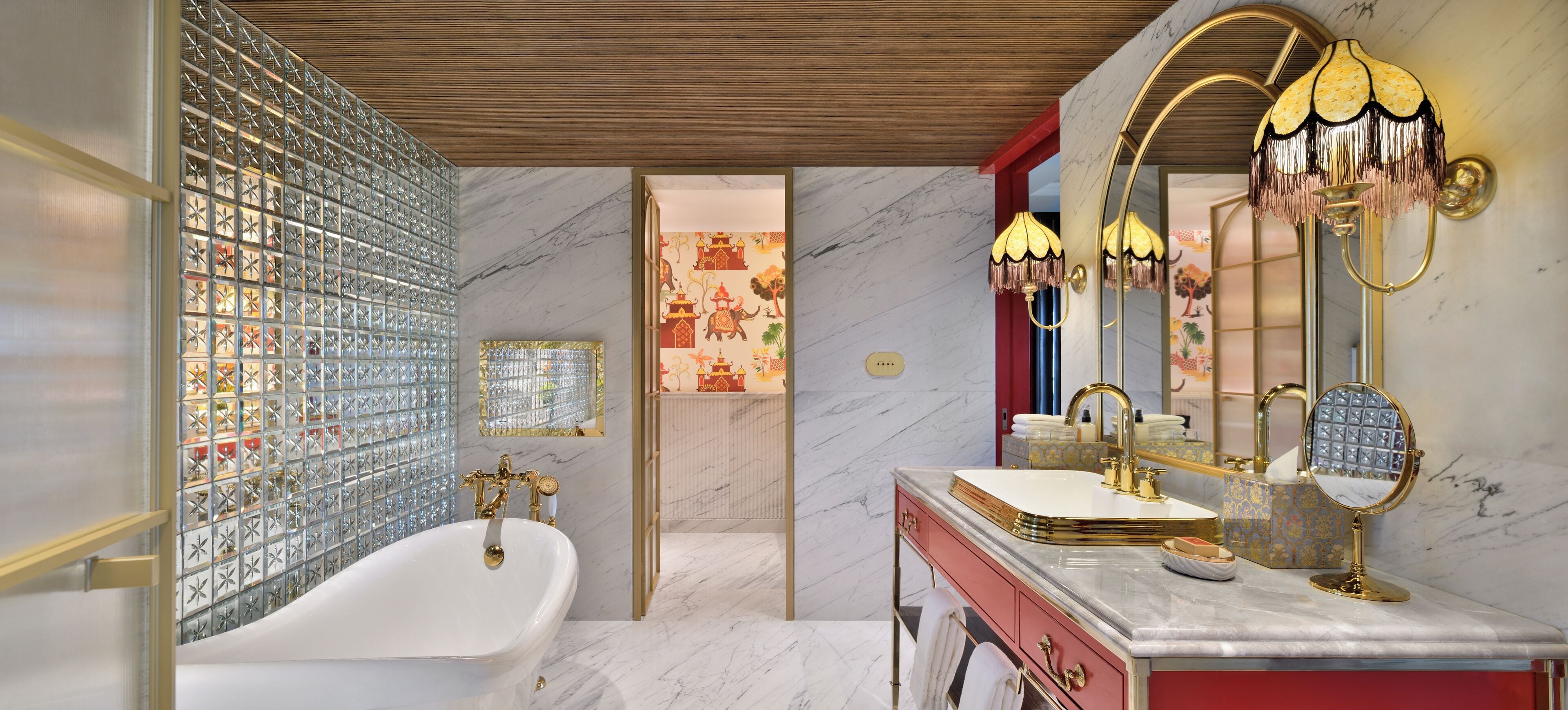 A luxurious bathroom with a freestanding bathtub, a vanity with a large mirror, and a decorative wall panel.
