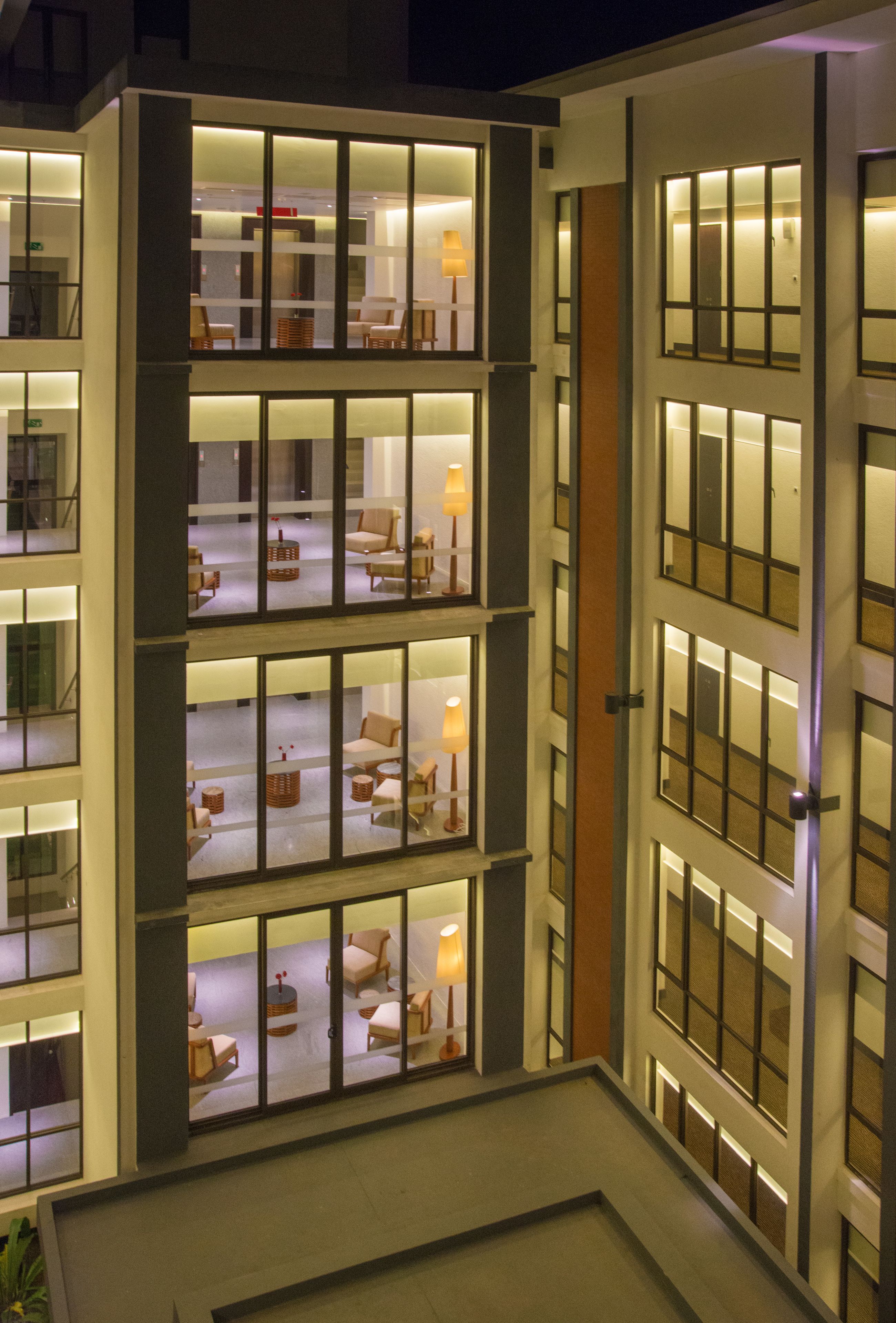 Ein mehrstöckiges Hotel mit zahlreichen Zimmern pro Etage, großen Fenstern und modernem architektonischem Design.