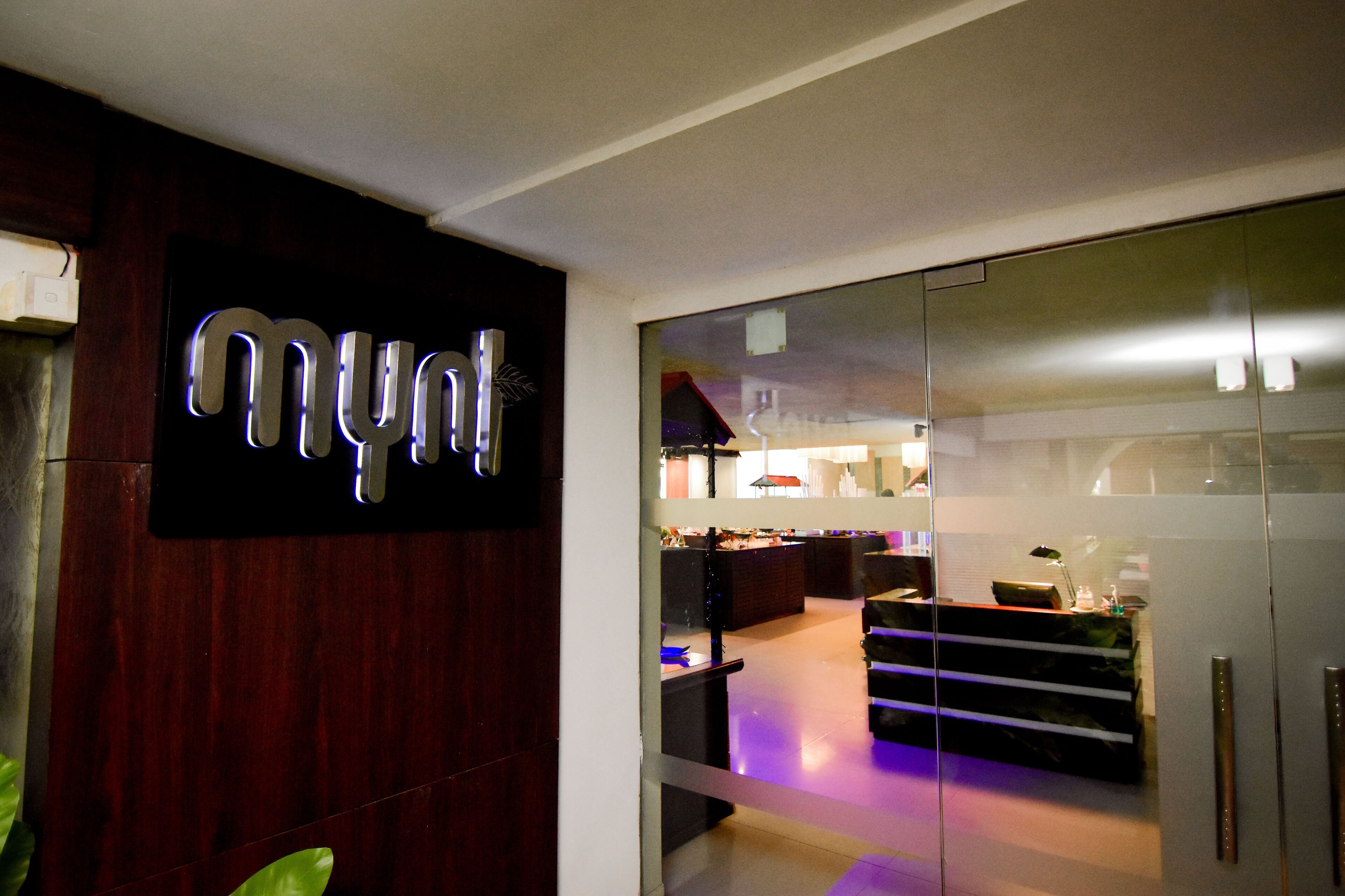 Een modern interieur met een 'mynd' bord, een receptiebalie en een glazen scheidingswand.