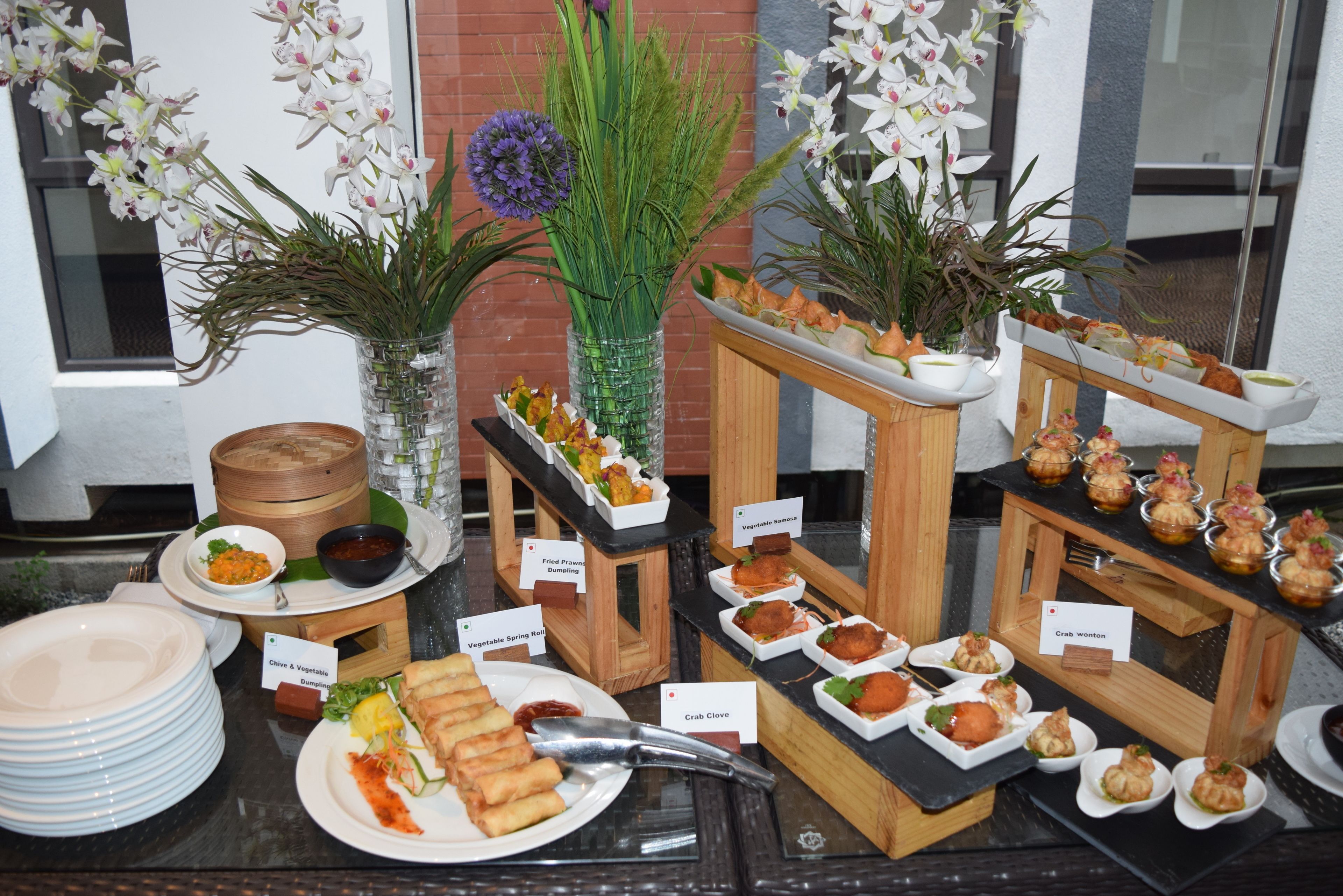 Un bufé con diversos platos, entre ellos rollitos de primavera, patas de cangrejo y rollitos primavera de verduras.