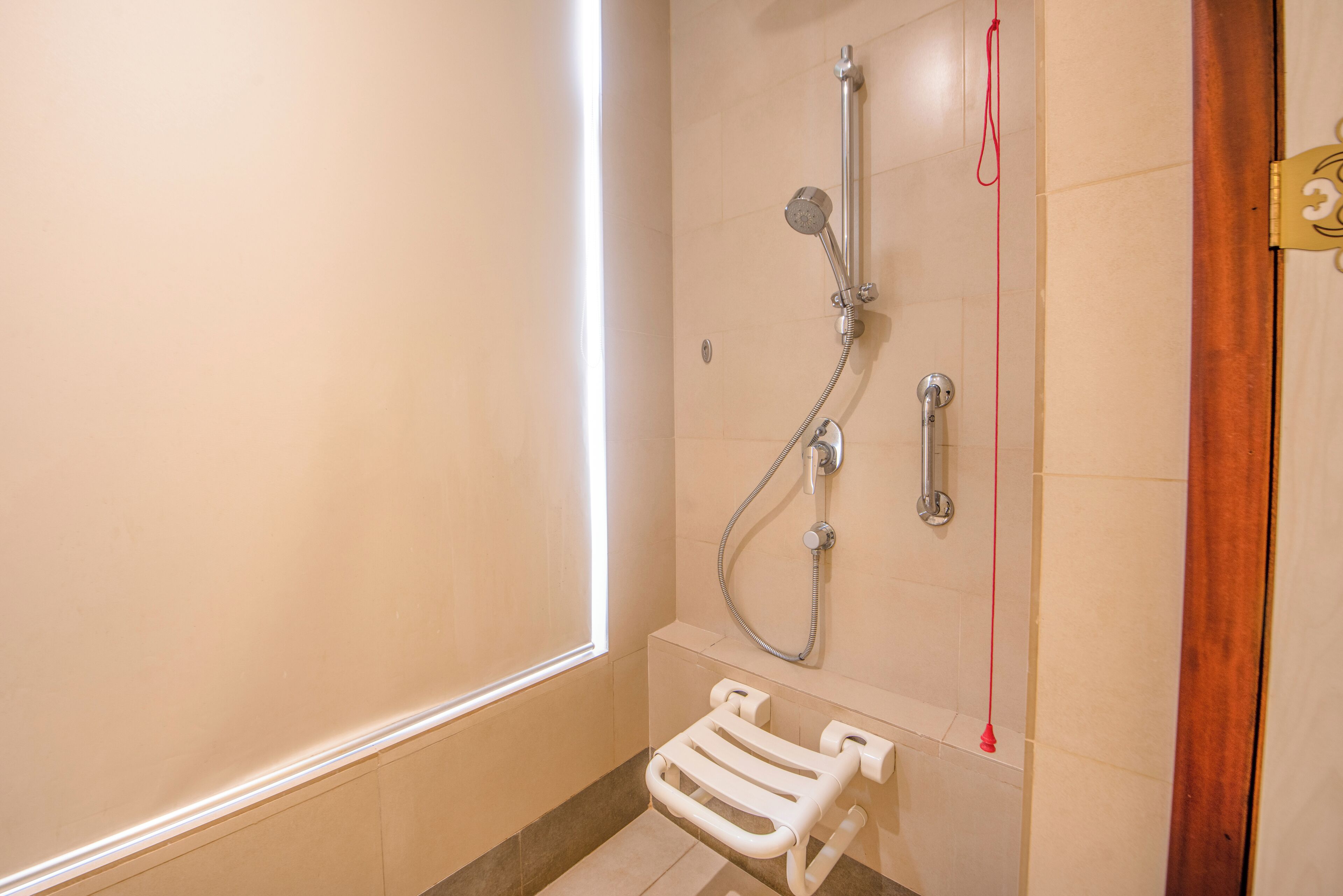Un baño con ducha, inodoro y toallero.