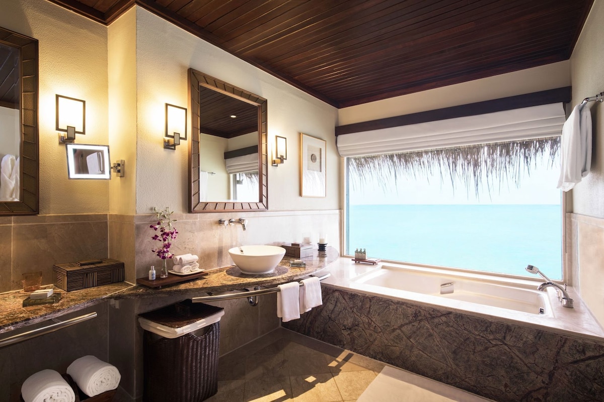 Une salle de bain moderne avec une grande baignoire, un lavabo et un miroir.