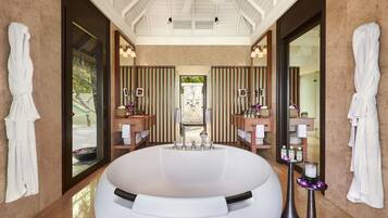 Bathroom features a large bathtub, two vanity mirrors, and recessed lighting.