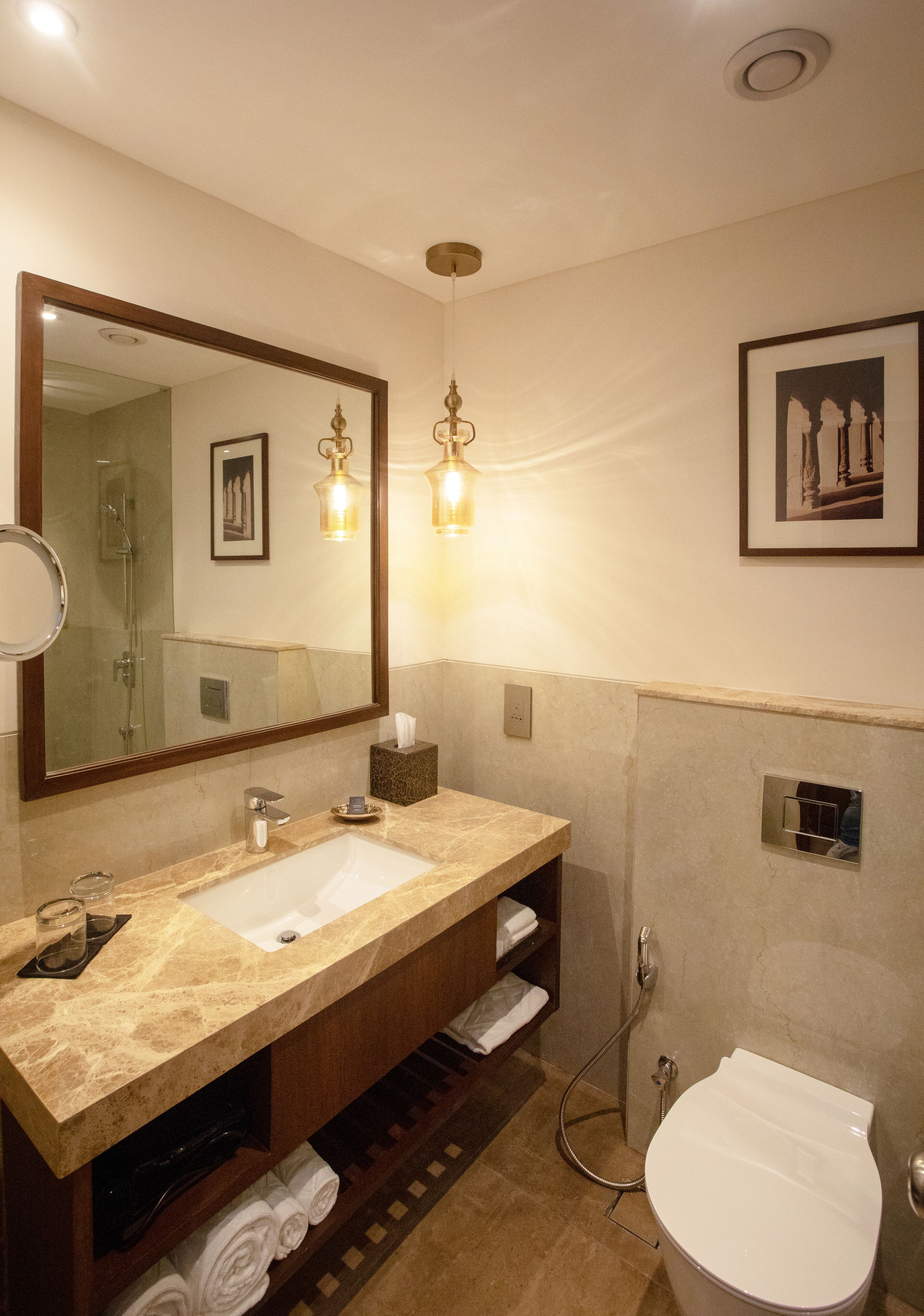 Un baño con un espejo grande, dos lavamanos, un inodoro y una ducha.