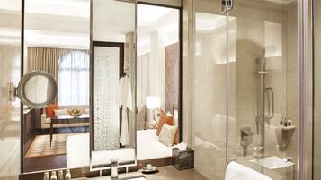A modern bathroom with a large mirror, a sink, and a shower.