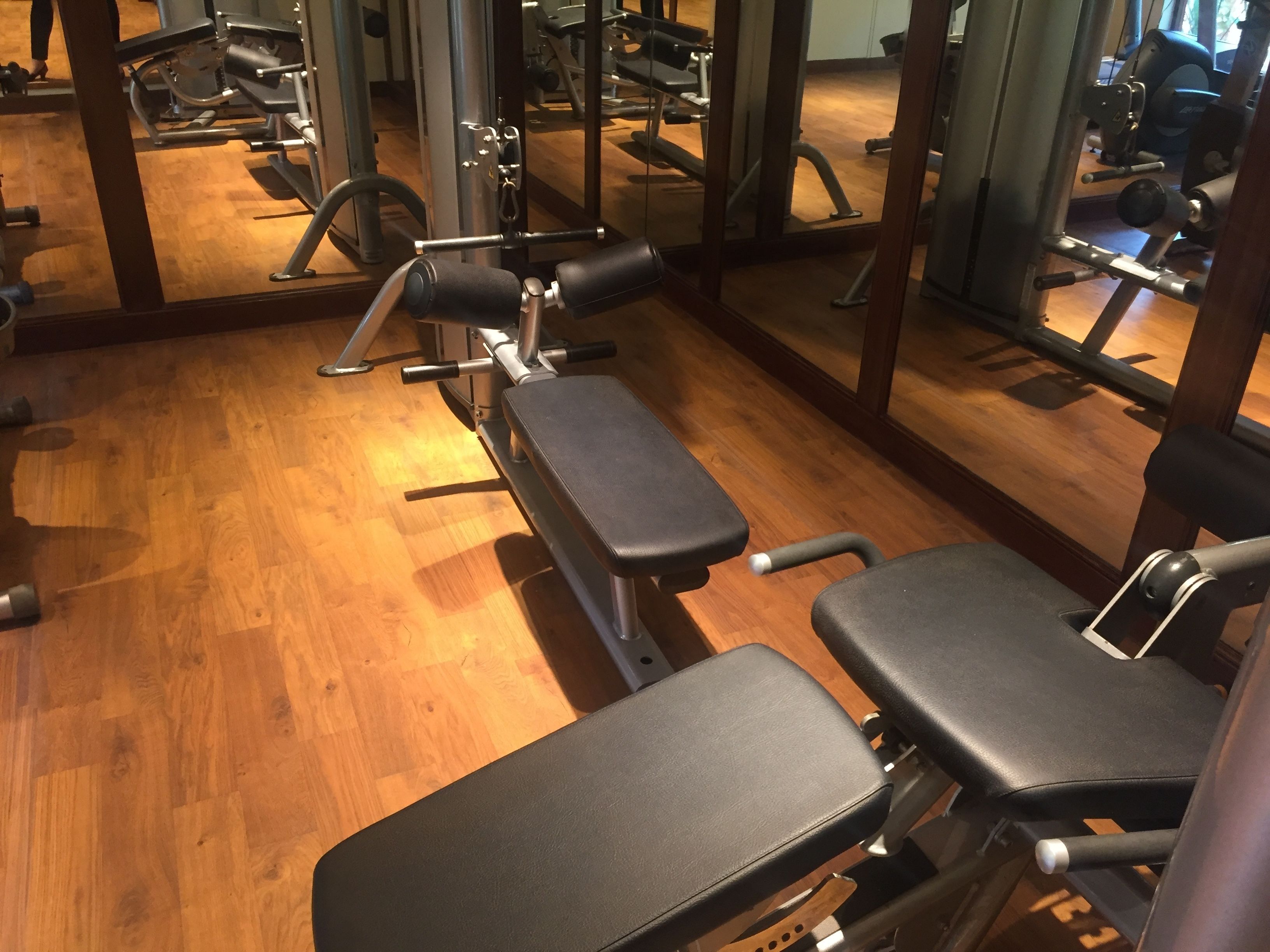 Een sportschool met trainingsapparatuur, waaronder banken en krachttoestellen.