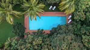 An aerial view of a rectangular swimming pool surrounded by lush greenery and palm trees. - Gateway Madurai (Madurai)