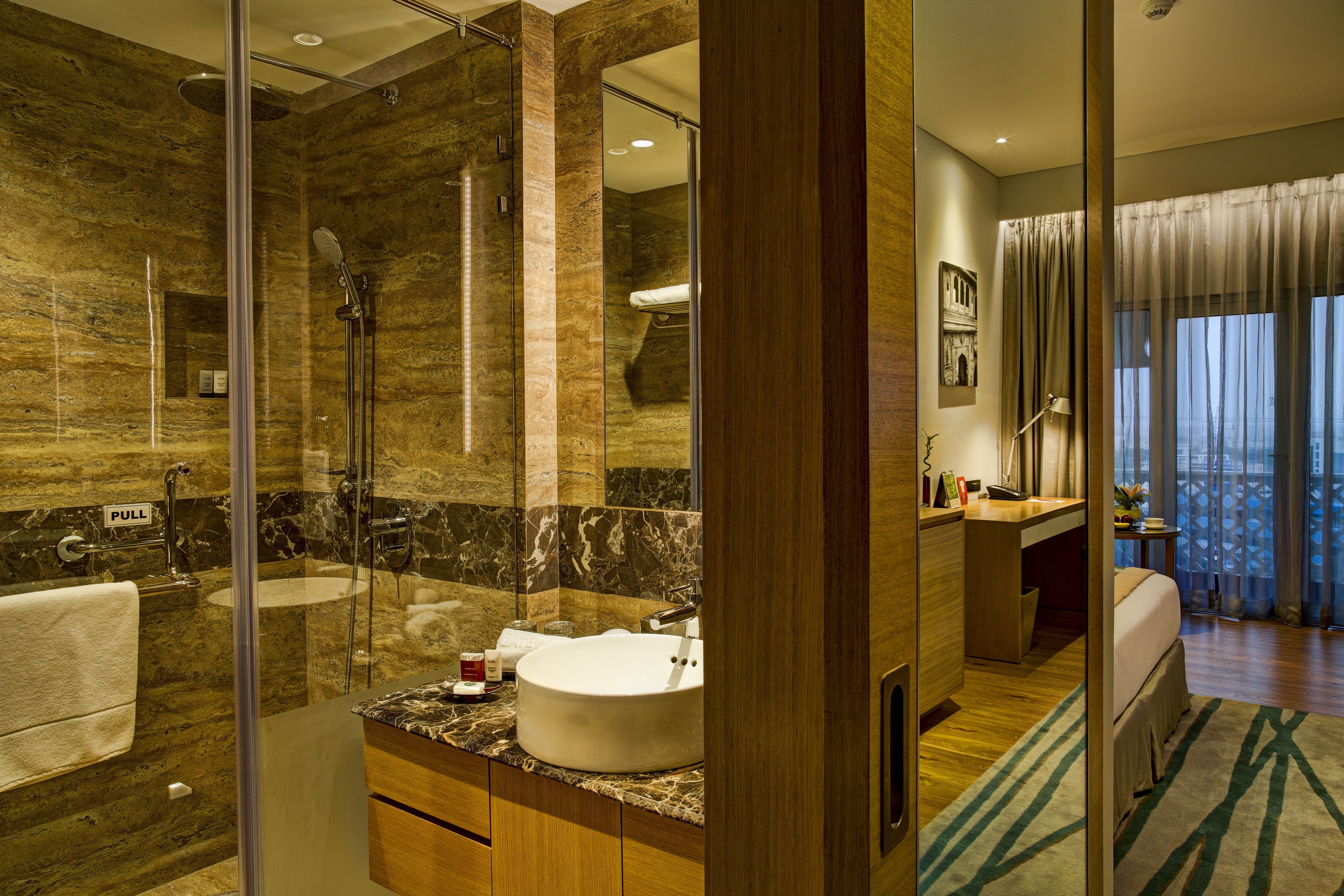 Un baño moderno con ducha de vidrio, lavamanos y tocador.