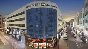 Un hotel moderno con fachada curva, amplios ventanales y un letrero llamativo que dice 'Admiral Plaza Hotel'.