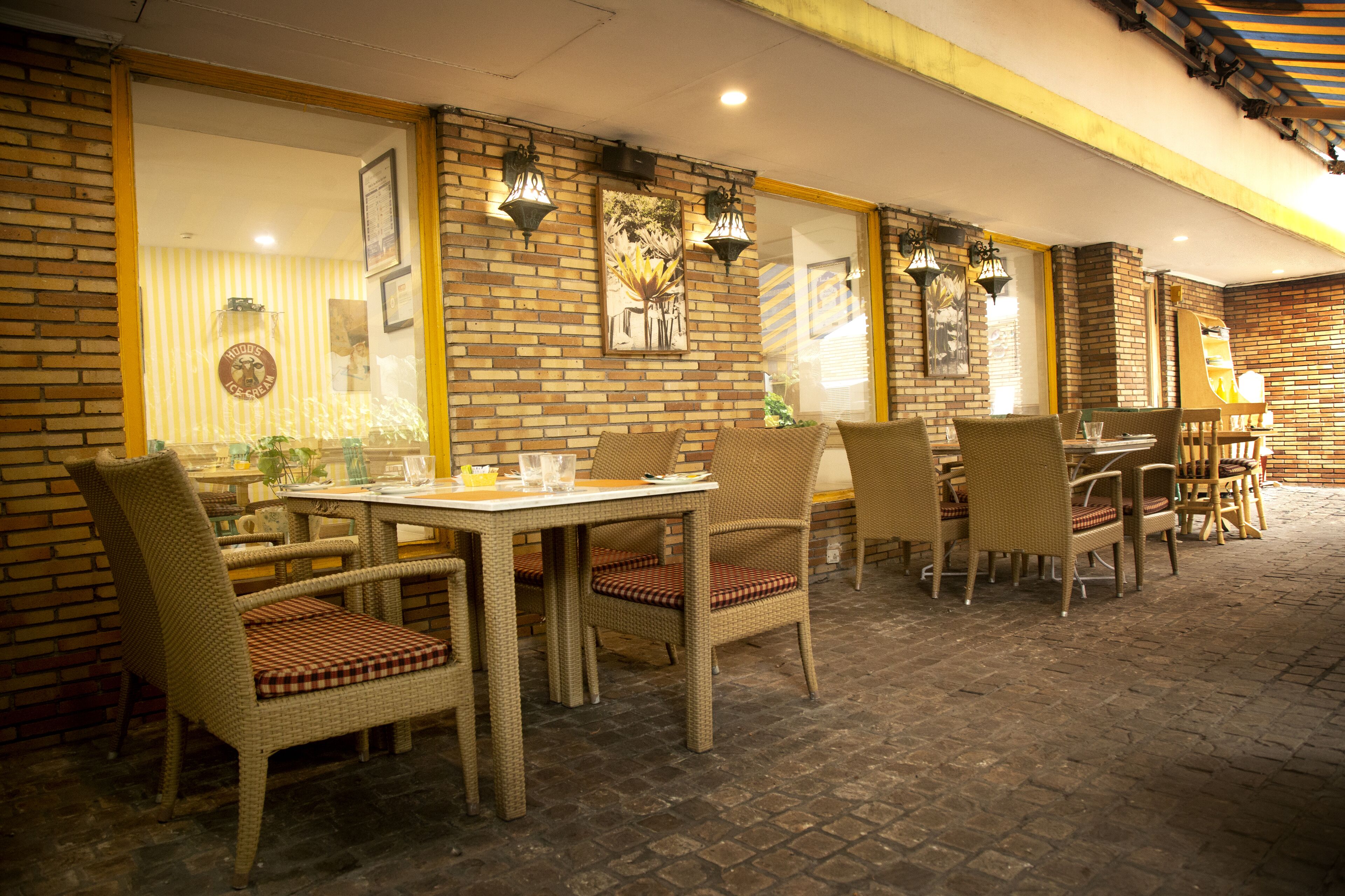 An outdoor dining area with wicker furniture and brick walls.