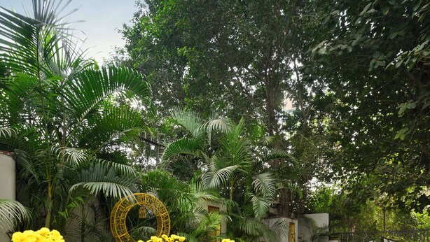 An outdoor patio with wicker furniture and yellow flower pots. - Ambassador, New Delhi - IHCL SeleQtions (New Delhi)