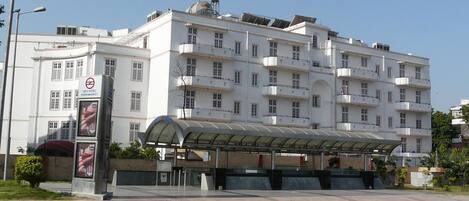 A multi-story building with a covered waiting area and a no parking sign.