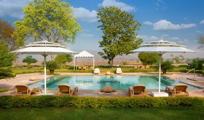 Outdoor pool, open 7:00 AM to 6:00 PM, pool umbrellas, sun loungers - Ramgarh Lodge, Jaipur - IHCL SeleQtions (Jamwa Ramgarh)