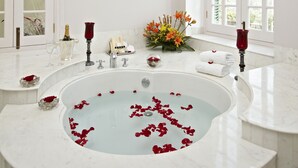Un bagno spazioso con una grande vasca, un mobile lavabo con specchio e una finestra che garantisce luce naturale.