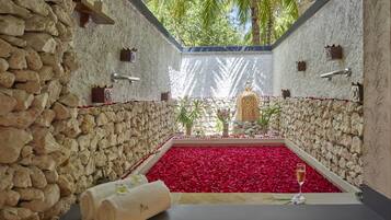 Relax in a serene spa area with a hot tub, surrounded by calming decor and a peaceful outdoor view.