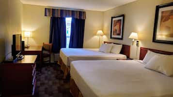 A hotel room with two beds, a desk, a chair, a TV, and two lamps.