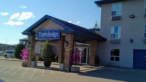 Et Travelodge hotel med facade af mursten, markise i blåt og en skilt.
