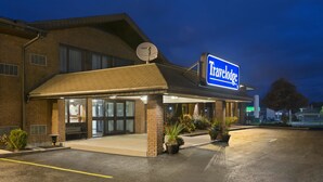 A Travelodge hotel with a brick facade, large windows, and a satellite dish. - Travelodge by Wyndham Owen Sound (Owen Sound)