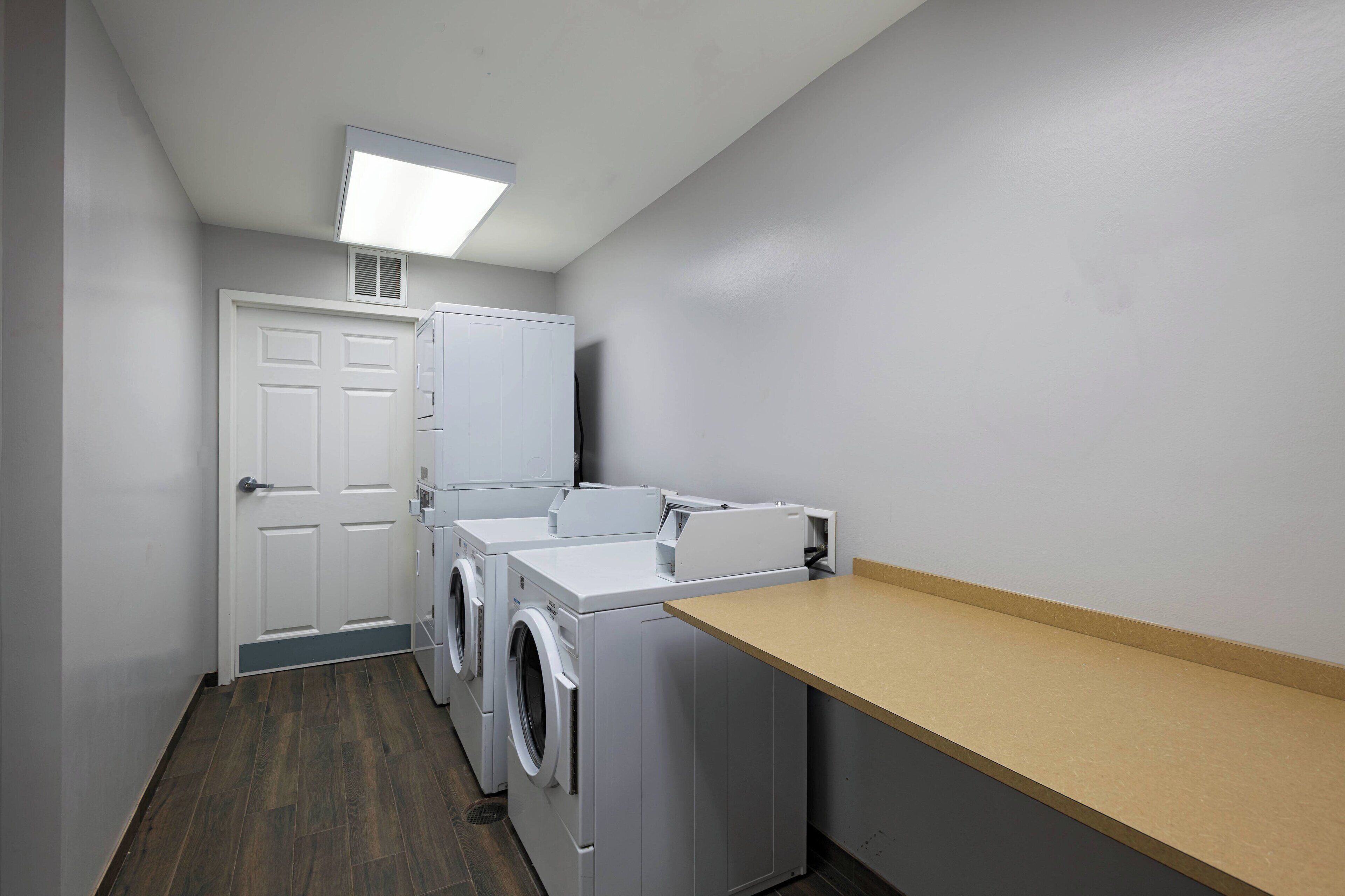 A laundry room with a washing machine, dryer, and a countertop.