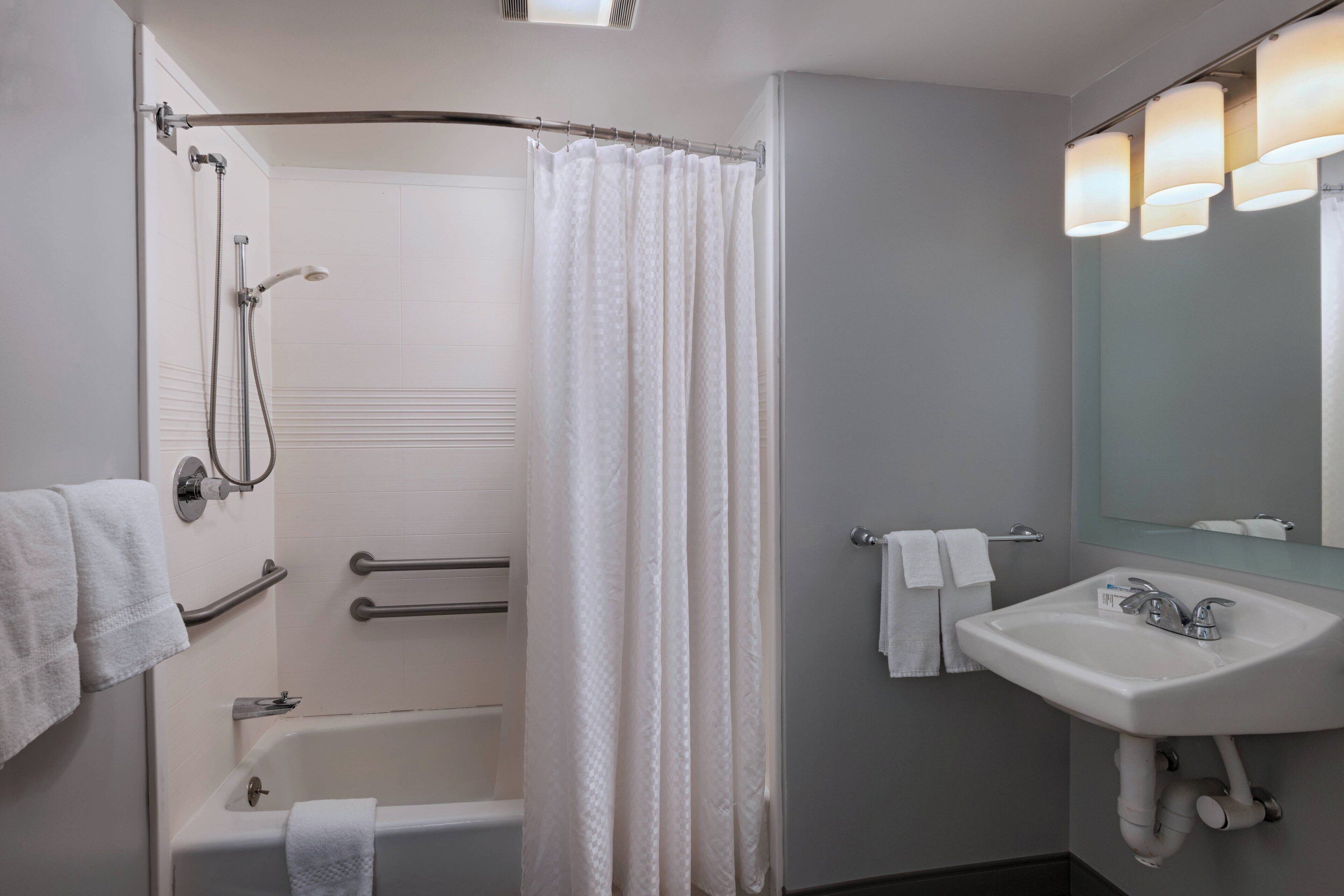 Un baño moderno con bañera, ducha y lavabo.