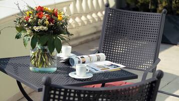 Ein Metalltisch mit einer Blumenvase, einer Tasse, einem Untertasse und einer Zeitung.