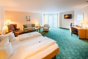 A hotel room with a bed, a sofa, a chair, a desk, and a television. - Best Western Hotel Am Papenberg (Goettingen)