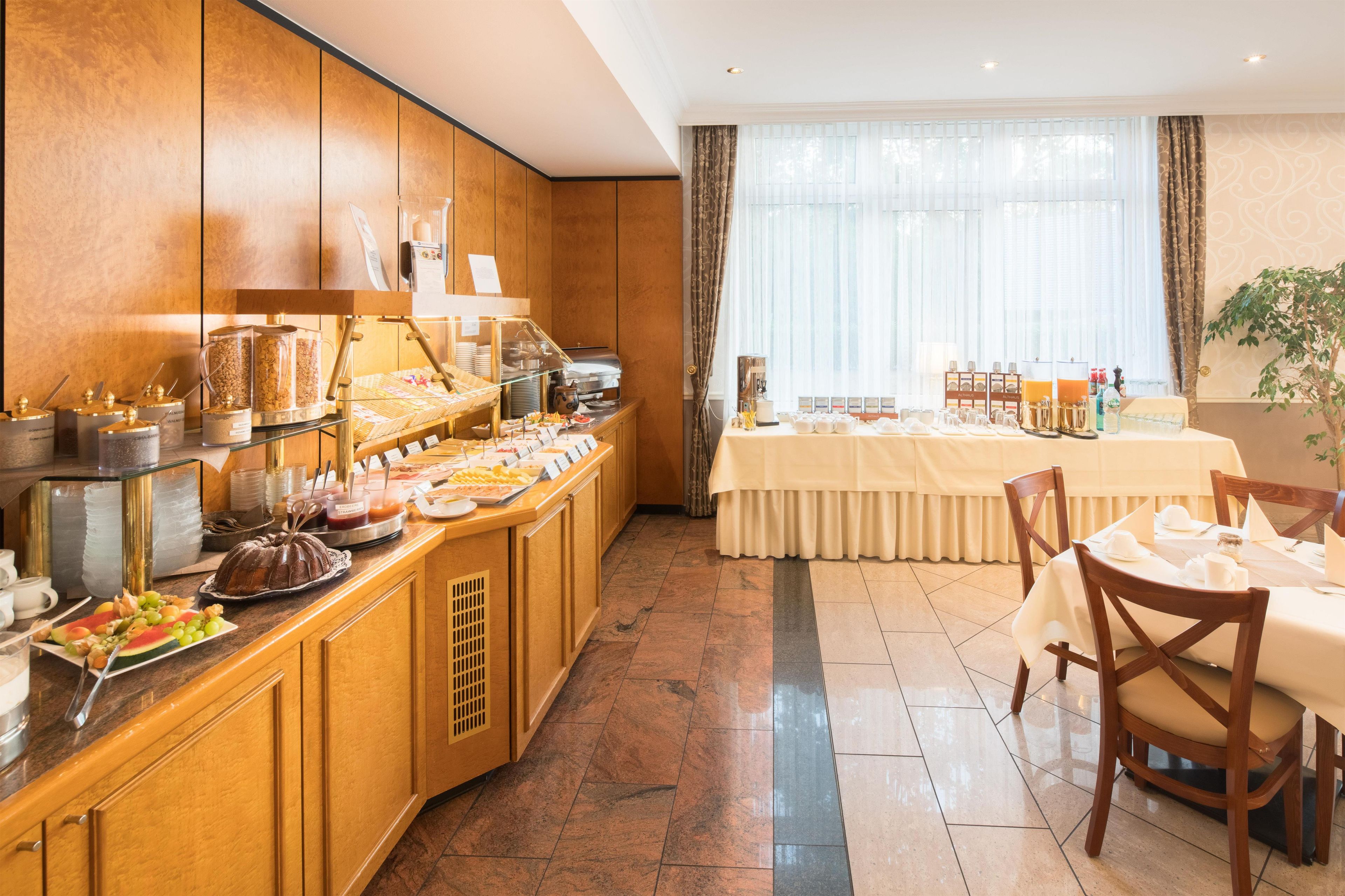 A buffet area with a variety of food options and a dining table set for two.