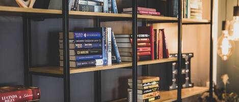 Una estantería con varios libros, un objeto decorativo y una lámpara.