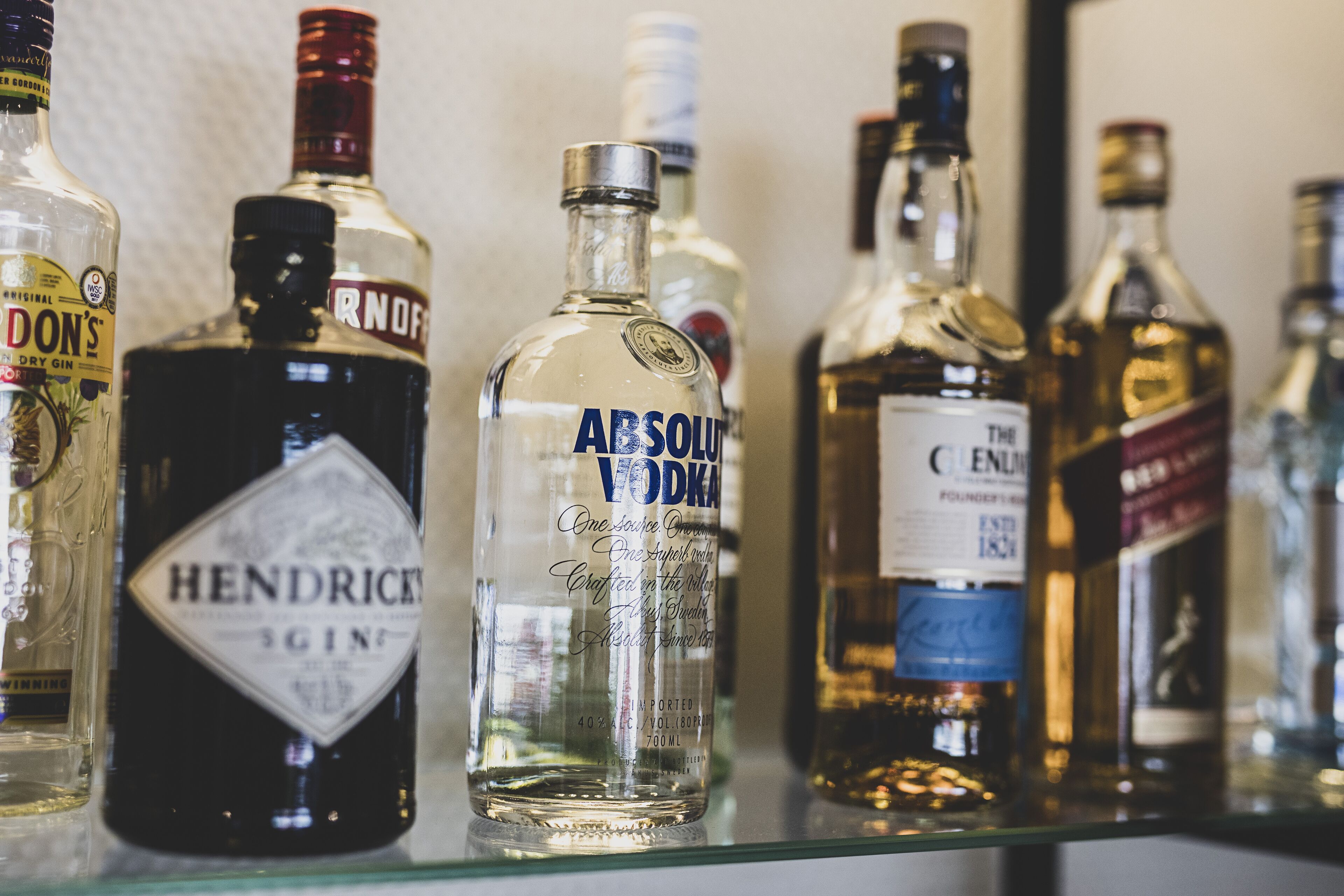 A variety of liquor bottles on a shelf.