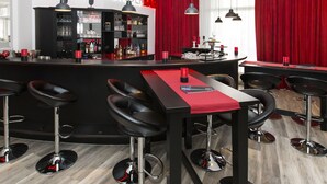 Zona de bar con mostrador, taburetes y una barra repleta de botellas.