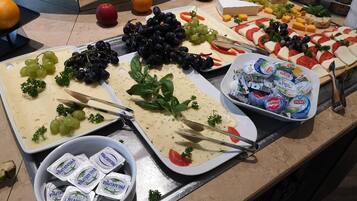 Ein Buffet mit verschiedenen Käsesorten, Früchten und Dips.