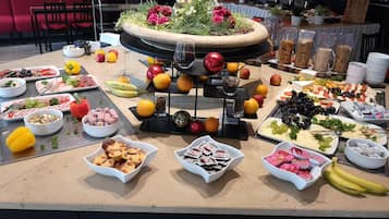 A buffet table with various food items and a decorative centerpiece.