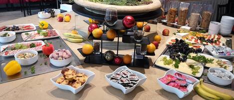 Una mesa de buffet con diversos alimentos y un centro de mesa decorativo.