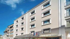 A multi-story hotel with a prominent 'TITANIC' sign, featuring a modern facade and a ground-level entrance.