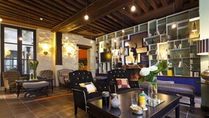 Una sala de estar moderna con chimenea, asientos cómodos y una estantería llena de libros y objetos decorativos.