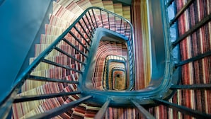 Una escalera de caracol con alfombra a rayas.