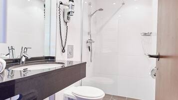 Une salle de bain moderne équipée d’une douche, de toilettes et d’un lavabo.