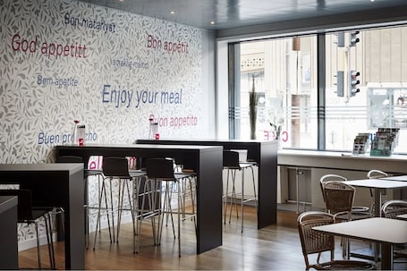 A modern restaurant interior with a patterned wall, bar area, and seating arrangement.