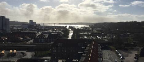 Une vue urbaine comprenant une rivière, un pont et un parking.